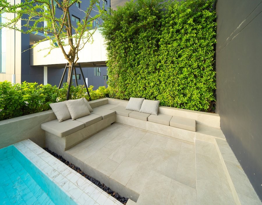 Residential community walkway with concrete pavers, tropical landscaping, and multi-family buildings in Jupiter, FL